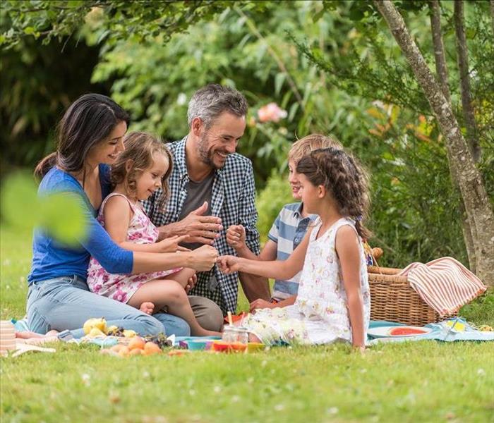 Cheerful family sitting on the grass during a picnic in a park