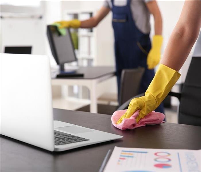 Janitor wiping table in office