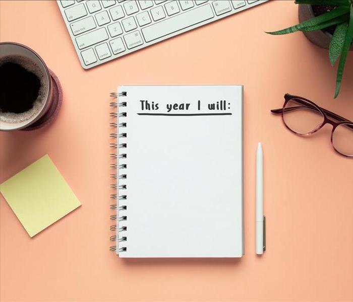 2020 new year notebook with list of resolutions and objects on pink background